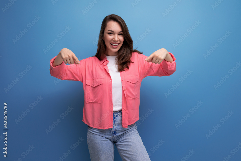smart brunette lady casual style pointing finger at space for information on studio background smart brunette lady casual style pointing finger at space for information on studio background