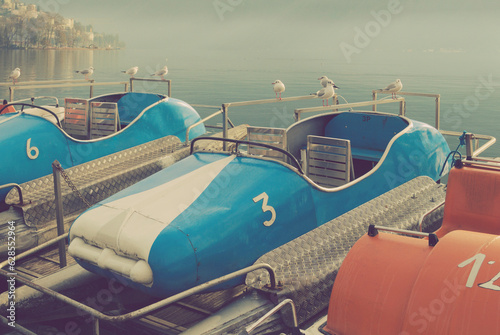 old pedalos and seagulls by the lake, Lugano, Switzerland photo