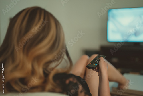 Woman watching erotic film at home.