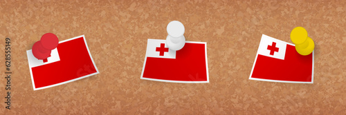 Tonga flag pinned in cork board, three versions of Tonga flag.