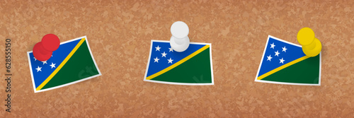 Solomon Islands flag pinned in cork board, three versions of Solomon Islands flag.