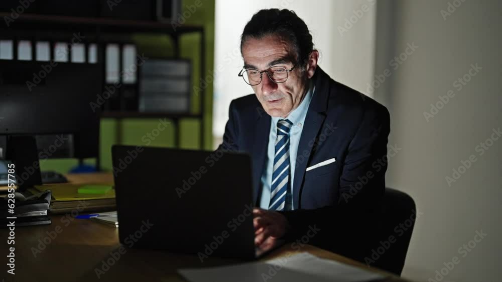 Middle age man business worker stressed using laptop taking glasses off at the office Middle age man business worker stressed using laptop taking glasses off at the office
