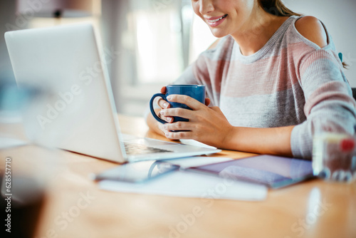 Quadro su tela Young woman using a laptop at home to study and work