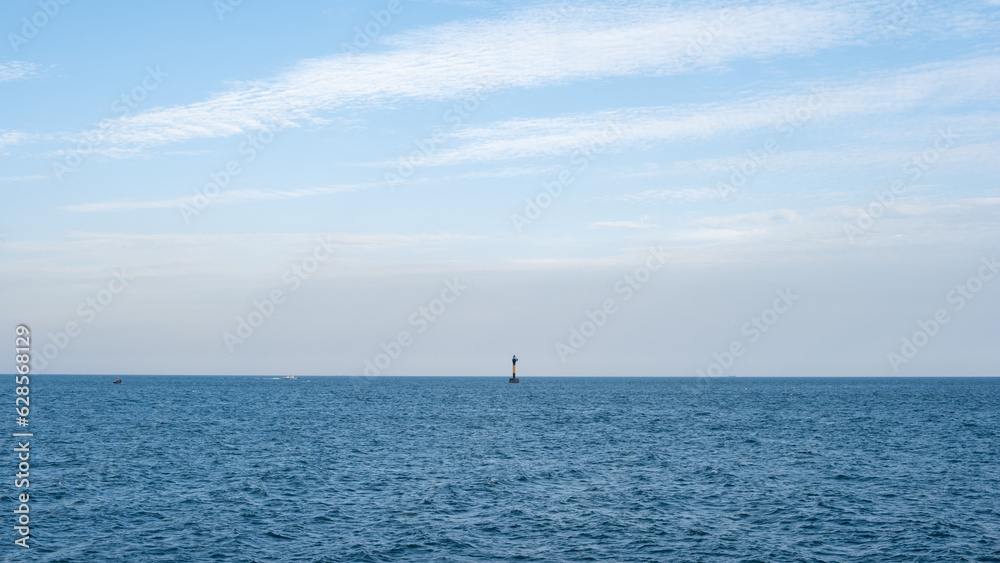 the blue sea, sea buoys, and a sky adorned with clouds