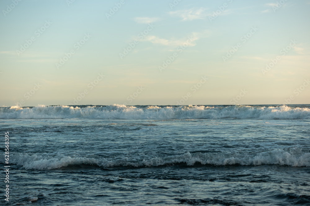an empty, clear day at the beach with tranquil waves an empty, clear day at the beach with tranquil waves