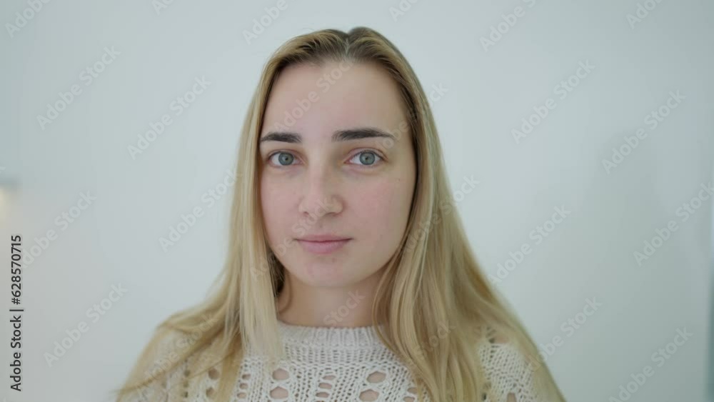 A young girl stands on a white background and looks at the camera A young girl stands on a white background and looks at the camera