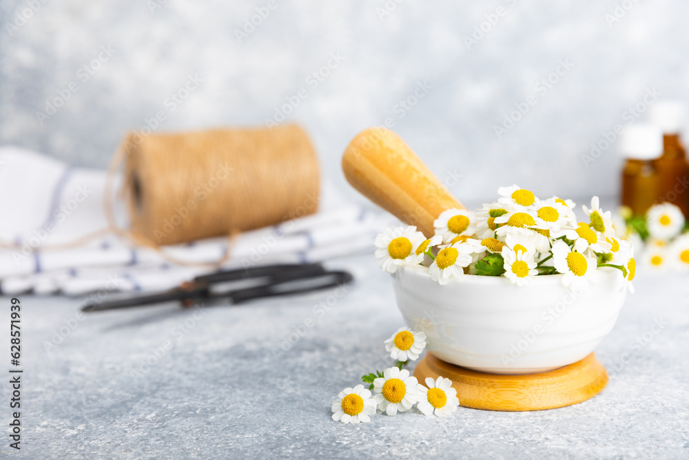 Chamomile flowers in mortar on a textured wooden table. Healing herbs. Alternative medicine. Healing. Homeopathy.Natural herbal organic cosmetics concept.Natural tea.Place for text. Copy space. 