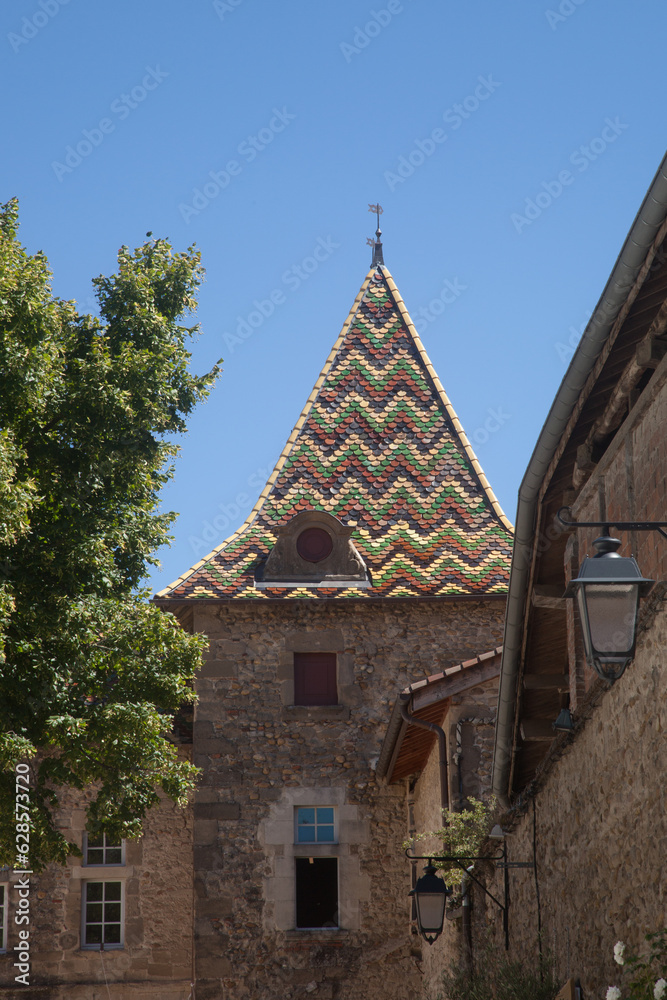 Tour surmontée d'un toit en tuiles vernissées dans le village de Saint-Antoine l'abbaye (Isère)