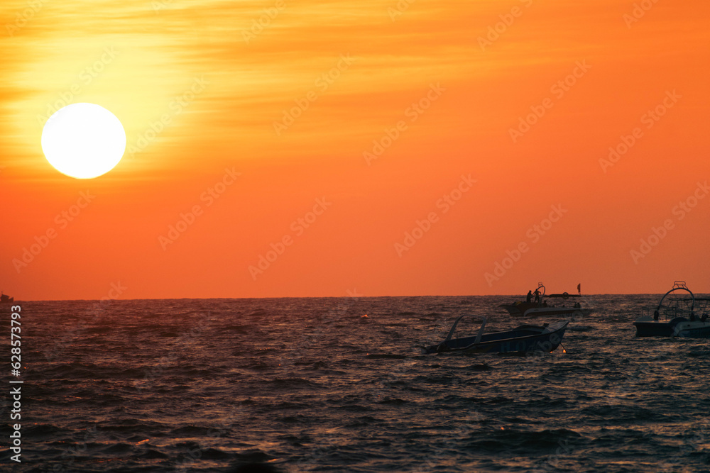 Silhouettes of fishing boats with sunset on the sea. The sun goes down on the sea.