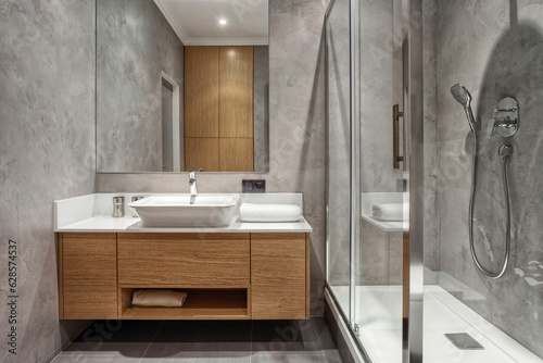 shower glass cabin and wash bowl in stylish hotel bathroom