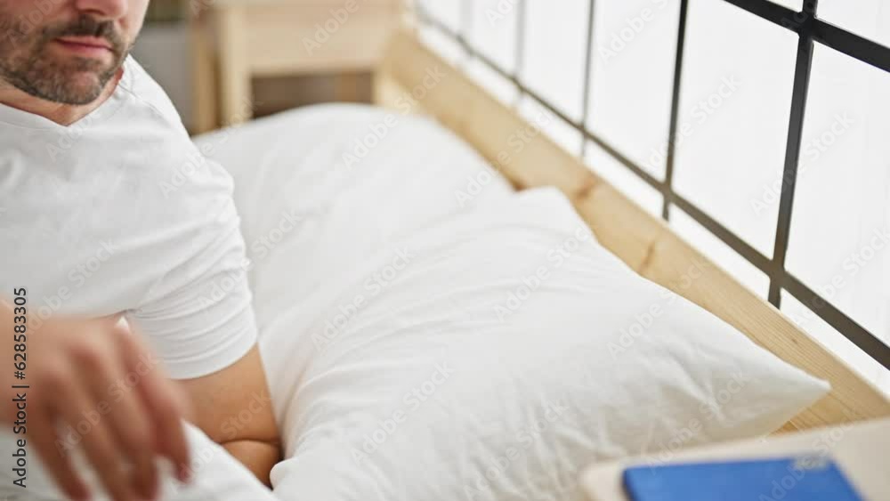 Grey-haired man waking up for smartphone call at bedroom