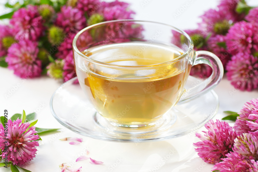 Red clover tea or infusion in glass bottle on white background with flowers, closeup, remedy for menopause, source of estrogen, used in cosmetics, spa, face and hair beauty Red clover tea or infusion in glass bottle on white background with flowers, closeup, remedy for menopause, source of estrogen, used in cosmetics, spa, face and hair beauty
