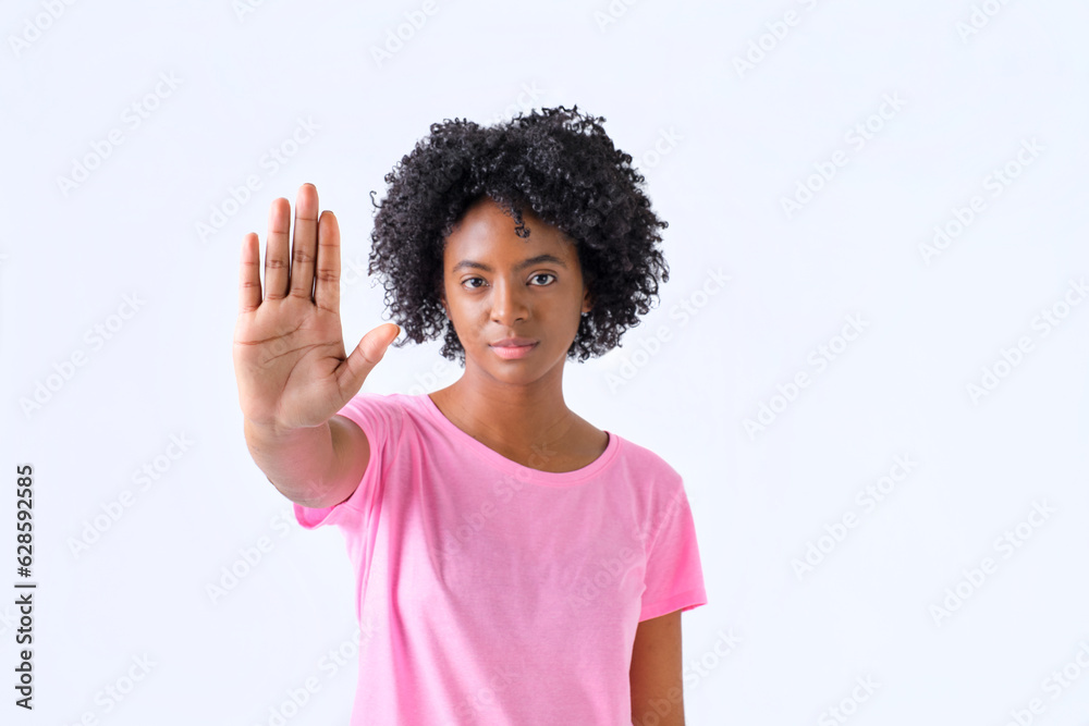 colombian girl with hand forward with stop gesture in pink t-shirt on white background