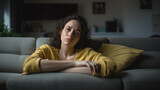 Woman Suffering From Depression Sitting On Bed In Pajamas
