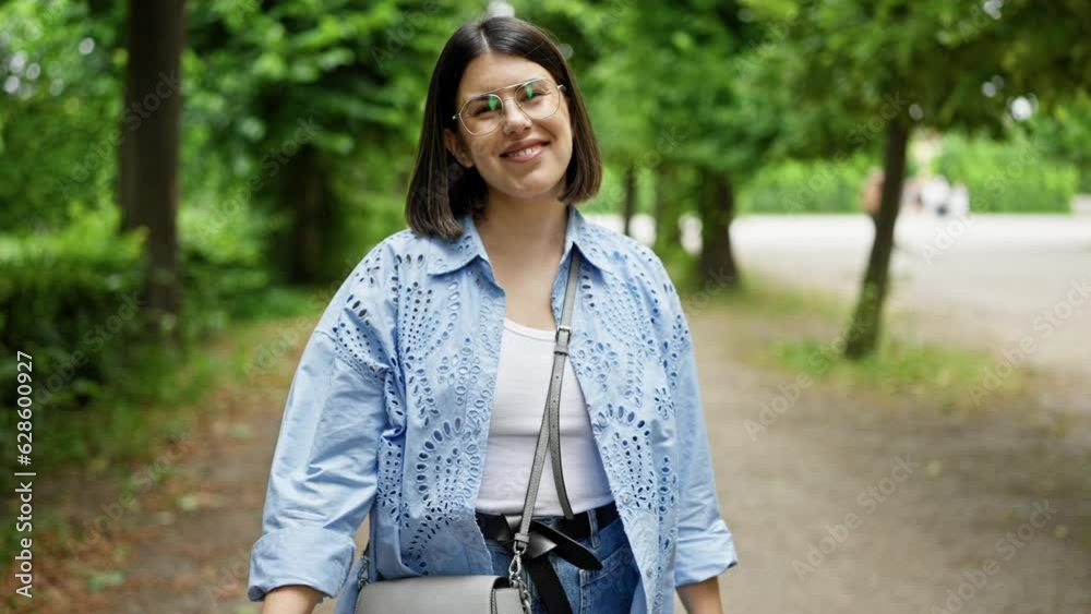 Young beautiful hispanic woman walking smiling at the park in Vienna