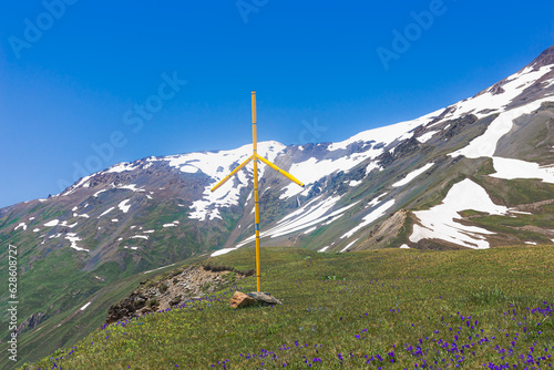 Traditional Georgian cross on the background of snow-capped mountains. Traditions of the highlanders of Georgia - Svans. Upper Svaneti, Samegrelo-Zemo Svaneti, Region in Georgia. close up
 photo