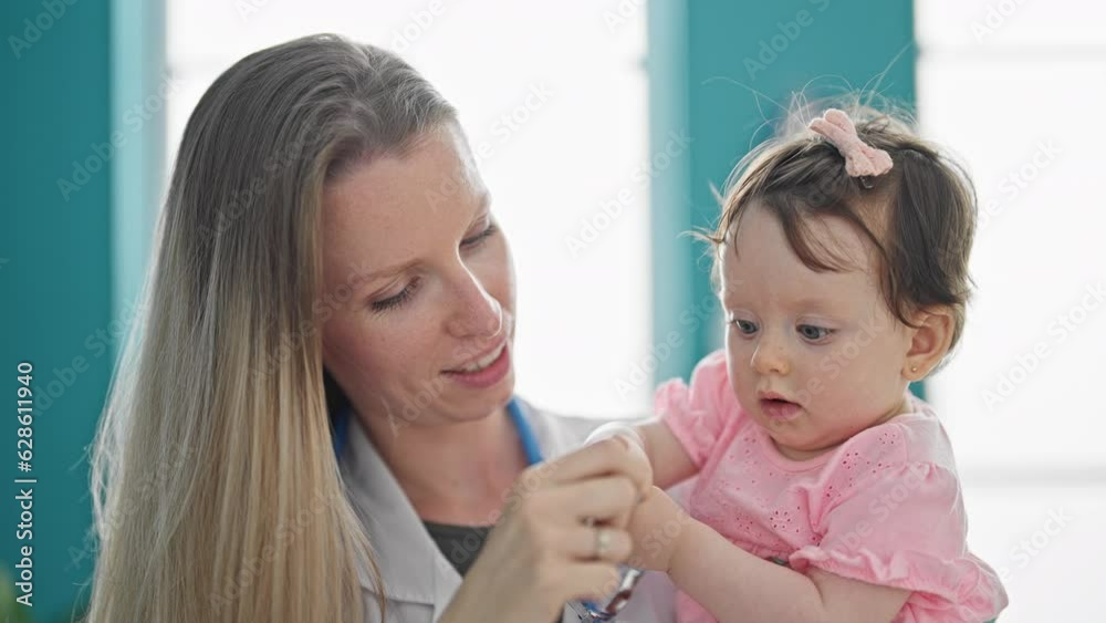 Mother and daughter playing with stethoscope at clinic Mother and daughter playing with stethoscope at clinic