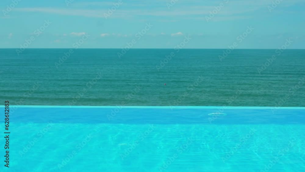 Beautiful Relaxing Sea View from the Infinity Outdoor Swimming Pool and Blue Sunny Sky with White Clouds. Beauty, Relax, Travel, Vacation. Beach Villa Resort. Beautiful Relaxing Sea View from the Infinity Outdoor Swimming Pool and Blue Sunny Sky with White Clouds. Beauty, Relax, Travel, Vacation. Beach Villa Resort.