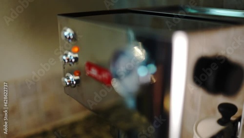 Hand turn off button on espresso coffee machine.  Slow motion