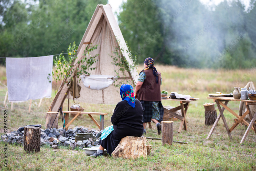  Refugee camp. Women sit in an open refugee camp.