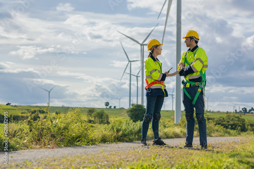 Engineer team man and woman field working together survey plan construction wind turbine clean power generator