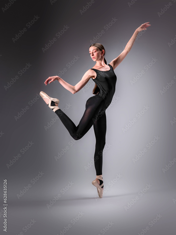 Obraz premium Young slender model-looking dancer with long hair in black tight-fitting dancewear in action