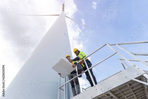 Wind turbine engineer technician male team working service maintenance survey construction site. Eco power energy generator for sustainable people worker.
