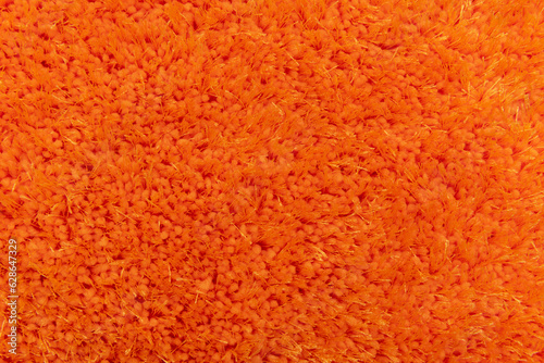 Texture of orange terry bath towel. Carpet background