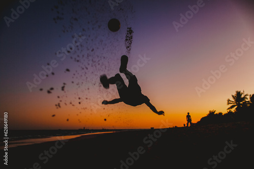 niño jugando a la pelota en un atardecer naranja