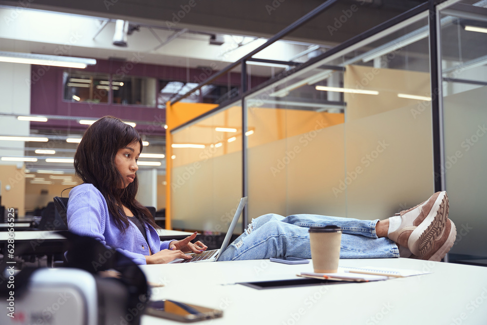 Female employee doing work assignments in modern room Female employee doing work assignments in modern room