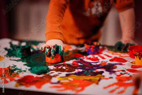 Cute little toddler boy painting with fingers at home. Creative games for kids. Stay at home entertainment