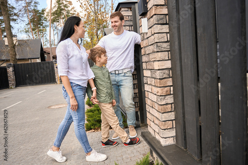 Caucasian family smiling enters their new home