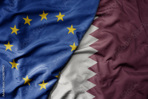 big waving realistic national colorful flag of european union and national flag of qatar .