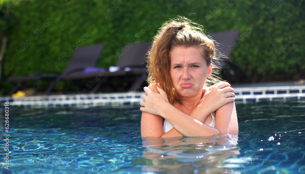 young woman in cold pool, wrinkled from the cold water at the summer in a hotel near sea