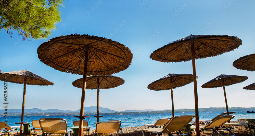 Idyllic view on Straw awning  on the beach on Greek  Island - fantastic vacations on ecological Spetses , Hydra,