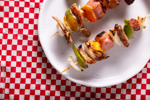 Homemade Skewers with meat and grilled vegetables served on a rustic wooden board, also known as brochettes, alambre, chuzo or pincho. Table topview. Closeup view. photo