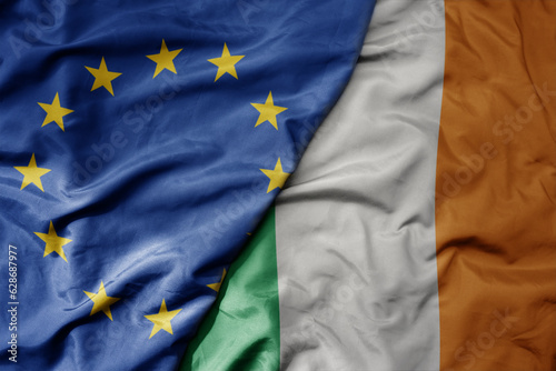 Photography big waving realistic national colorful flag of european union and national flag of ireland