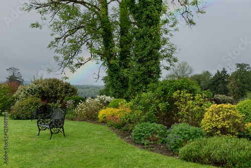 Photography Secluded country garden landscape with benches trees shrubs and shrubbery flower