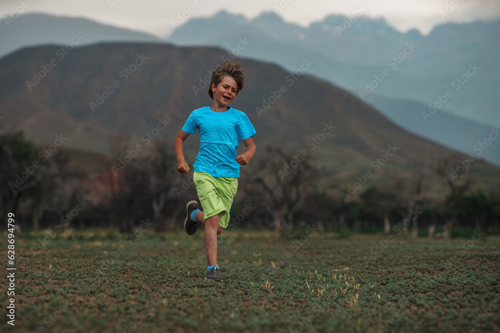 Happy boy running on mountains background