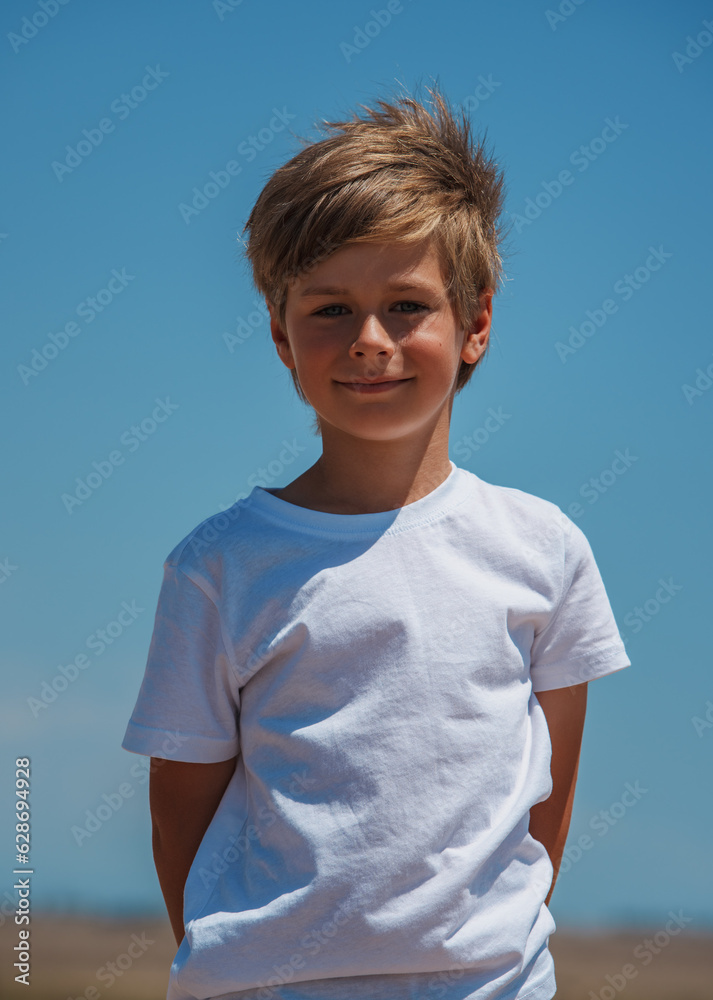 Portrait of beautiful smiling boy on blue sky background Portrait of beautiful smiling boy on blue sky background