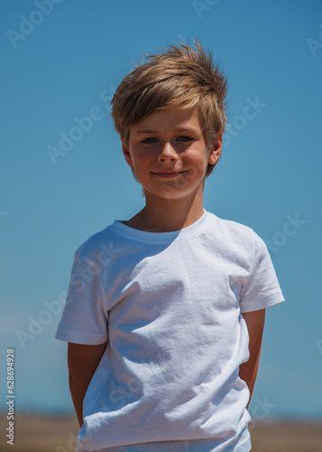 Portrait of beautiful smiling boy on blue sky background