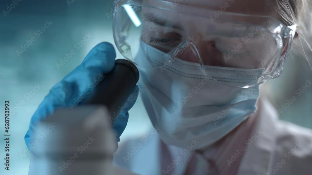 Medical science laboratory. A microbiologist wearing glasses is looking under microscope analyzing sample. Scientist pharmacist working with forensic. Genetic dna research and pharmaceutics concept