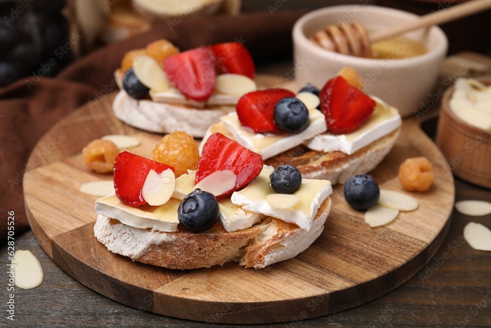 Tasty brie cheese sandwiches served on wooden table, closeup