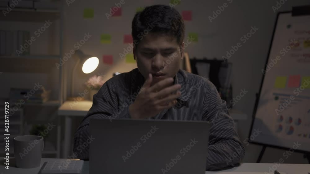 Stressed young asian businessman working overtime at the office night work too much Asian Chinese man working late at home restaurant Emotional stress with his financial bills alone at night Stressed young asian businessman working overtime at the office night work too much Asian Chinese man working late at home restaurant Emotional stress with his financial bills alone at night