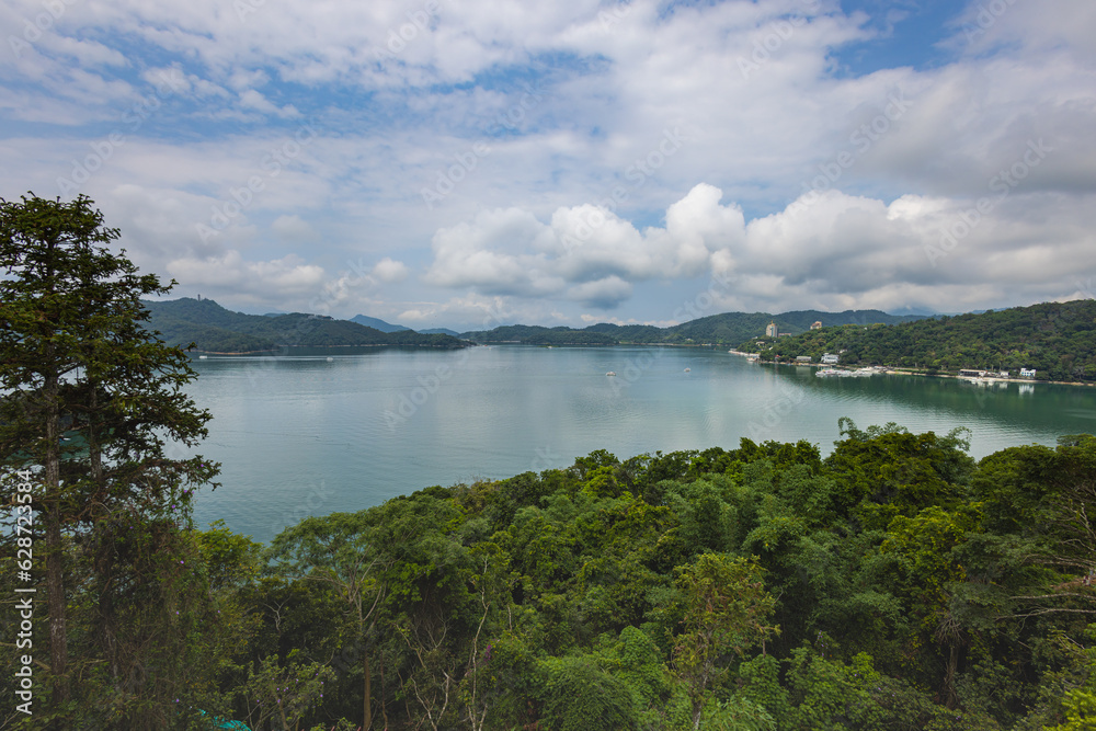 Captivating aerial view of Sun Moon Lake, Taiwan, showcases its serene beauty with lush greenery, crystal-clear waters, and encircling majestic mountains. A picturesque paradise In the heart of Taiwan