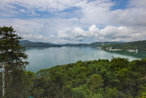 Captivating aerial view of Sun Moon Lake, Taiwan, showcases its serene beauty with lush greenery, crystal-clear waters, and encircling majestic mountains. A picturesque paradise In the heart of Taiwan © Holger