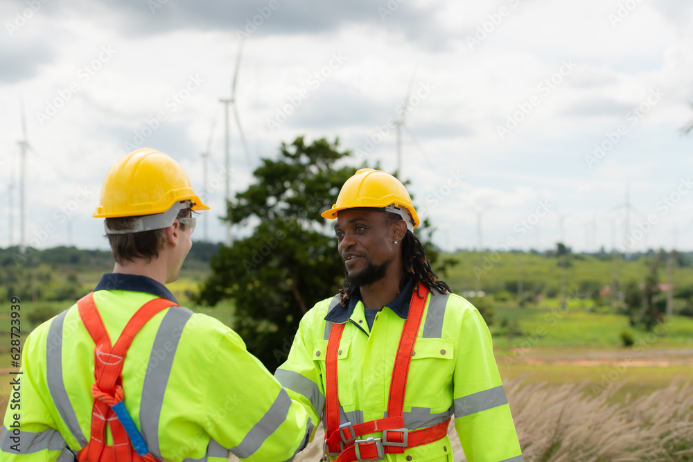 Engineer and technician discussing a solution problem of wind turbine before go in and check wind turbine, The concept of natural energy from wind. Engineer and technician discussing a solution problem of wind turbine before go in and check wind turbine, The concept of natural energy from wind.