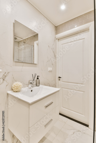 a bathroom with marble flooring and white walls  along with a large mirror on the wall above the sink