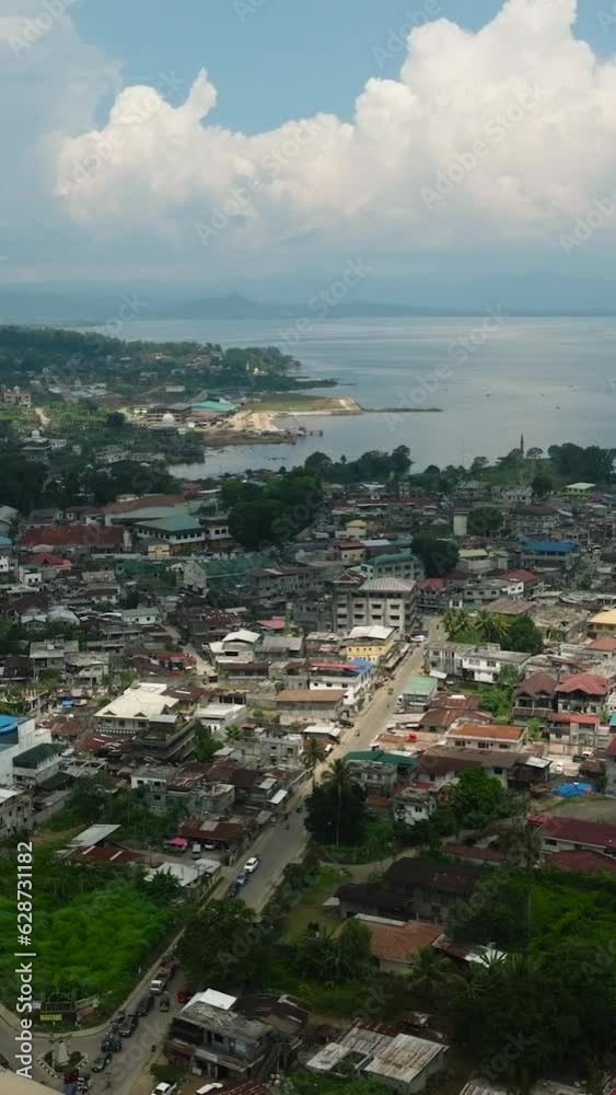 Cityscape: Marawi City with blue sky and clouds. Lanao del Sur. Mindanao, Philippines. Vertical view. Cityscape: Marawi City with blue sky and clouds. Lanao del Sur. Mindanao, Philippines. Vertical view.