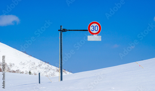 Road sign half buried under deep snow (Niseko, Hokkaido, Japan) photo